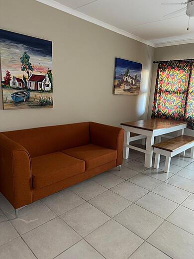 Lounge with an orange sofa and a dining table in the family studio